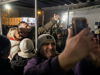 People take pictures with Kyiv Mayor Vitali Klitschko near Ukraine's main Christmas tree after its lights are switched on, amid Russia's att...