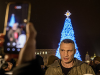 Kyiv Mayor Vitali Klitschko stands near Ukraine's main Christmas tree after its lights are switched on amid Russia's attack on Ukraine in So...