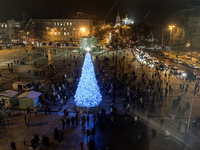 People walk around Ukraine's main Christmas tree after its lights are switched on amid Russia's attack on Ukraine in Sophia Square in Kyiv,...