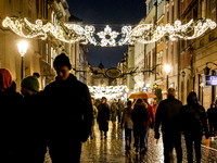 Visitors walk on landmark Florianska street near the Main Square as Christmas decorations become present in Krakow, Poland on October 6, 202...