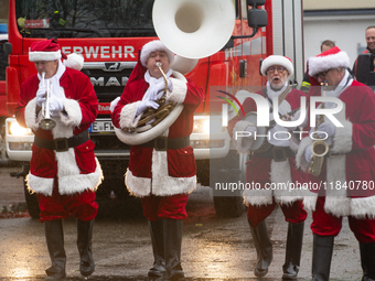 A local band dresses like Santa Claus before Santa Claus arrives by helicopter in Essen Steele, Germany, on December 6, 2024. (