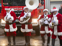 A local band dresses like Santa Claus before Santa Claus arrives by helicopter in Essen Steele, Germany, on December 6, 2024. (