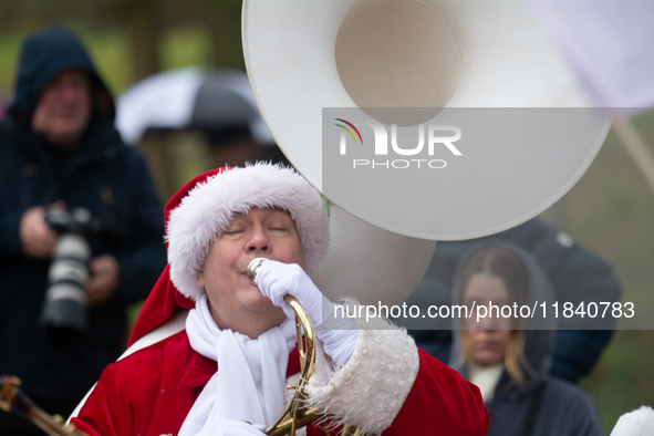 A local band dresses like Santa Claus before Santa Claus arrives by helicopter in Essen Steele, Germany, on December 6, 2024. 