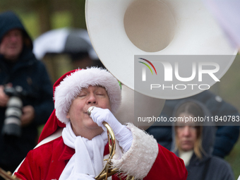 A local band dresses like Santa Claus before Santa Claus arrives by helicopter in Essen Steele, Germany, on December 6, 2024. (