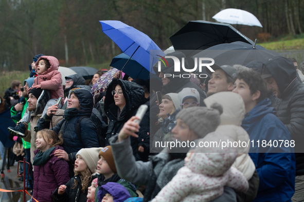 Children with parents wait for the landing of the helicopter with Santa Claus in Essen Steele, Germany, on December 6, 2024. 