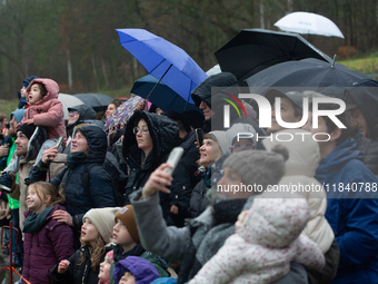 Children with parents wait for the landing of the helicopter with Santa Claus in Essen Steele, Germany, on December 6, 2024. (