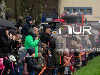 Children with parents wait for the landing of the helicopter with Santa Claus in Essen Steele, Germany, on December 6, 2024. (