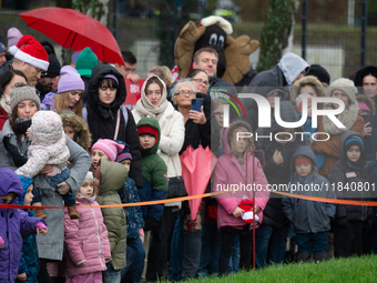 Children with parents wait for the landing of the helicopter with Santa Claus in Essen Steele, Germany, on December 6, 2024. (