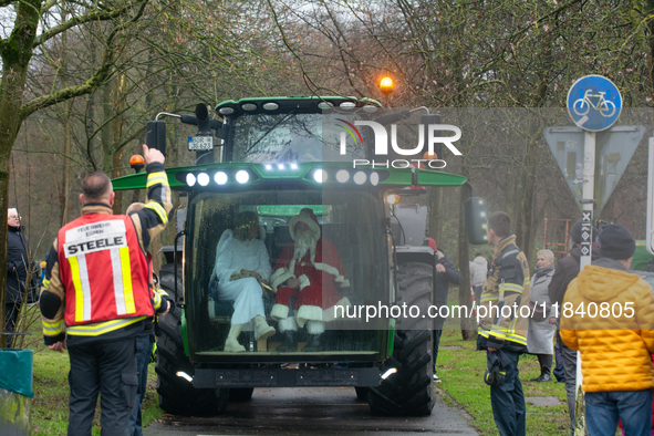 Santa Claus and an angel sit on a tractor and drive to the local Christmas market in Essen Steele, Germany, on December 6, 2024. 