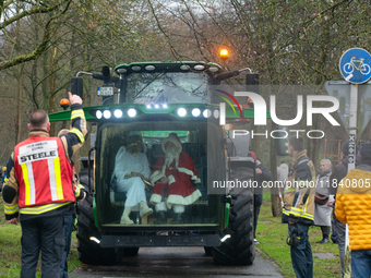 Santa Claus and an angel sit on a tractor and drive to the local Christmas market in Essen Steele, Germany, on December 6, 2024. (