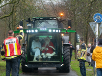 Santa Claus and an angel sit on a tractor and drive to the local Christmas market in Essen Steele, Germany, on December 6, 2024. (