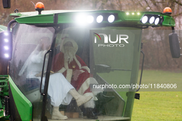 Santa Claus and an angel sit on a tractor and drive to the local Christmas market in Essen Steele, Germany, on December 6, 2024. 