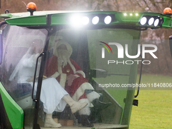 Santa Claus and an angel sit on a tractor and drive to the local Christmas market in Essen Steele, Germany, on December 6, 2024. (