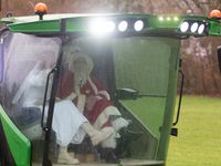 Santa Claus and an angel sit on a tractor and drive to the local Christmas market in Essen Steele, Germany, on December 6, 2024. (