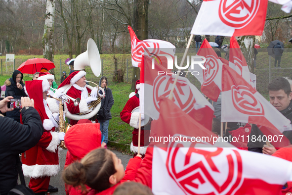 A local band dresses like Santa Claus before Santa Claus arrives by helicopter in Essen Steele, Germany, on December 6, 2024. 