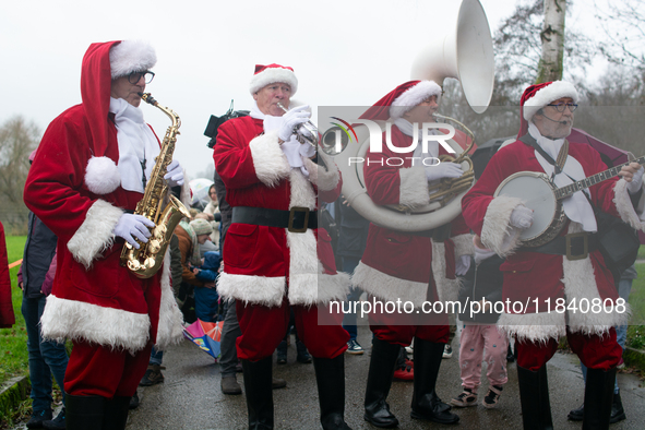 A local band dresses like Santa Claus before Santa Claus arrives by helicopter in Essen Steele, Germany, on December 6, 2024. 