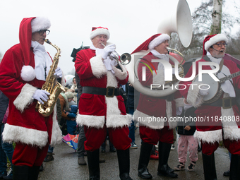 A local band dresses like Santa Claus before Santa Claus arrives by helicopter in Essen Steele, Germany, on December 6, 2024. (