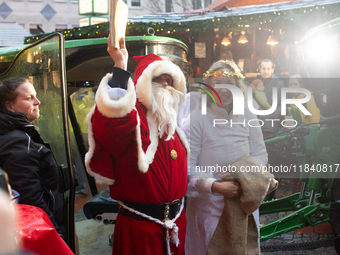 Santa Claus with an angel arrives at a local Christmas market in Essen Steele, Germany, on December 6, 2024. (