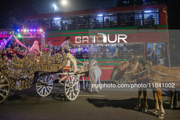 City dwellers ride on a horse cart during a public holiday in Dhaka, Bangladesh, on December 6, 2024. Horse cart rides, a nostalgic mode of...