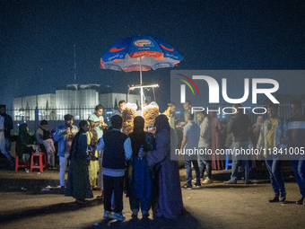 City dwellers gather in front of the National Parliament in Dhaka, Bangladesh, on December 6, 2024, during a public holiday. Makeshift shops...