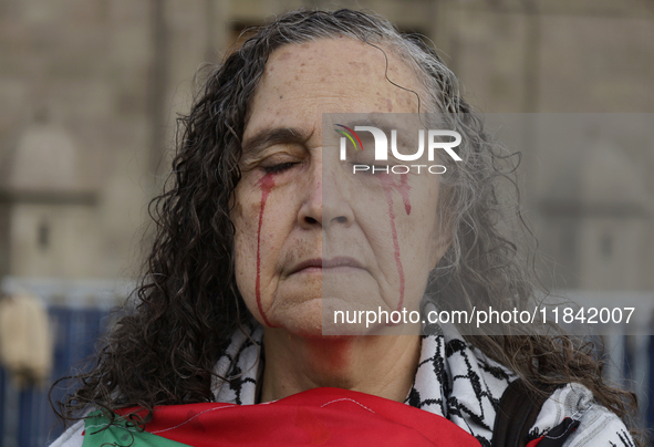 A woman sympathetic to Palestine demonstrates against the genocide in Gaza in the Zocalo of Mexico City, Mexico, on December 6, 2024, to dem...