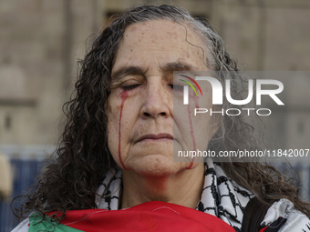 A woman sympathetic to Palestine demonstrates against the genocide in Gaza in the Zocalo of Mexico City, Mexico, on December 6, 2024, to dem...