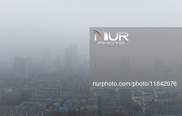 Buildings loom under heavy fog in Nanjing, China, on December 7, 2024. 