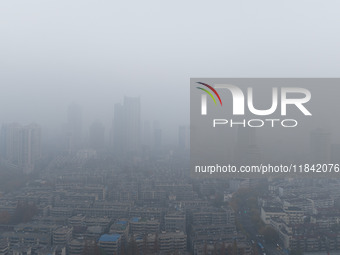 Buildings loom under heavy fog in Nanjing, China, on December 7, 2024. (