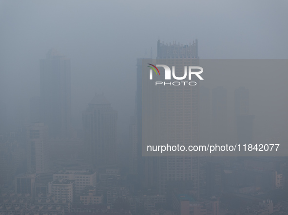 Buildings loom under heavy fog in Nanjing, China, on December 7, 2024. 