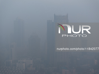 Buildings loom under heavy fog in Nanjing, China, on December 7, 2024. (