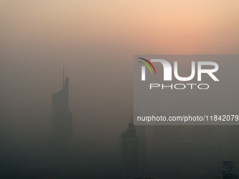 Buildings loom under heavy fog in Nanjing, China, on December 7, 2024. (