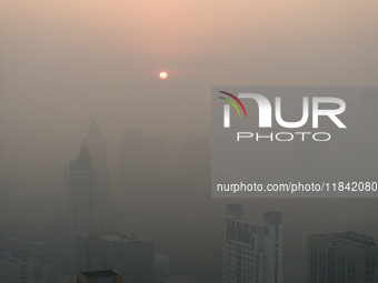 Buildings loom under heavy fog in Nanjing, China, on December 7, 2024. (