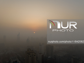 Buildings loom under heavy fog in Nanjing, China, on December 7, 2024. (