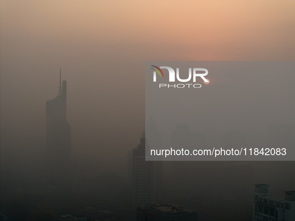 Buildings loom under heavy fog in Nanjing, China, on December 7, 2024. 