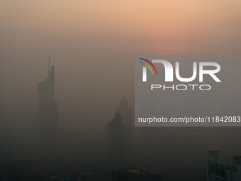 Buildings loom under heavy fog in Nanjing, China, on December 7, 2024. (