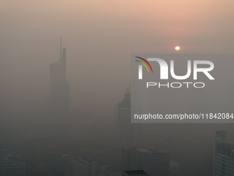 Buildings loom under heavy fog in Nanjing, China, on December 7, 2024. (