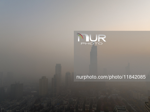 Buildings loom under heavy fog in Nanjing, China, on December 7, 2024. 