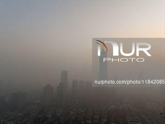 Buildings loom under heavy fog in Nanjing, China, on December 7, 2024. (