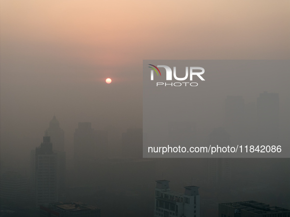 Buildings loom under heavy fog in Nanjing, China, on December 7, 2024. 