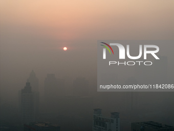 Buildings loom under heavy fog in Nanjing, China, on December 7, 2024. (