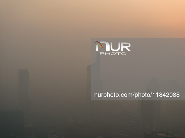 Buildings loom under heavy fog in Nanjing, China, on December 7, 2024. 