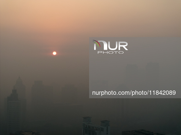 Buildings loom under heavy fog in Nanjing, China, on December 7, 2024. 