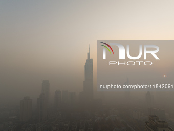 Buildings loom under heavy fog in Nanjing, China, on December 7, 2024. (