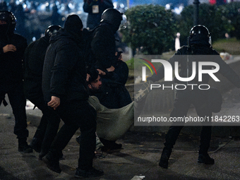 Police detain anti-government protesters during a ninth consecutive day of mass demonstrations against the government's postponement of Euro...