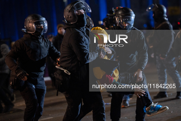 Police detain anti-government protesters during a ninth consecutive day of mass demonstrations against the government's postponement of Euro...