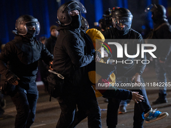 Police detain anti-government protesters during a ninth consecutive day of mass demonstrations against the government's postponement of Euro...