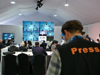 Media personnel inside the Media Centre watch a live telecast of Sheikh Mohammed bin Abdulrahman Al Thani, Prime Minister and Minister of Fo...