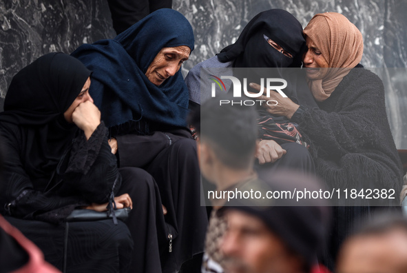 Palestinian women mourn relatives killed in an Israeli strike during their funeral at the al-Awda Hospital at the Nuseirat refugee Camp in t...