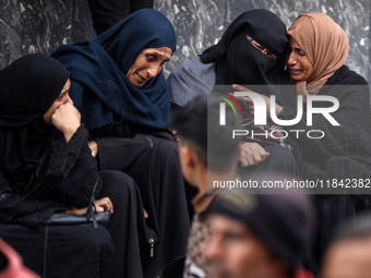 Palestinian women mourn relatives killed in an Israeli strike during their funeral at the al-Awda Hospital at the Nuseirat refugee Camp in t...