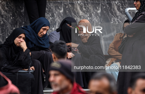 Palestinian women mourn relatives killed in an Israeli strike during their funeral at the al-Awda Hospital at the Nuseirat refugee Camp in t...